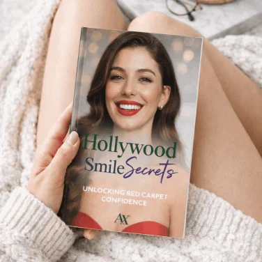 Hollywood Smile Secrets unlocking red carpet confidence bonus ebook held by smiling woman – free digital bonus with Axavive skin supplement